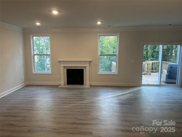 unfurnished living room with crown molding and dark wood-type flooring