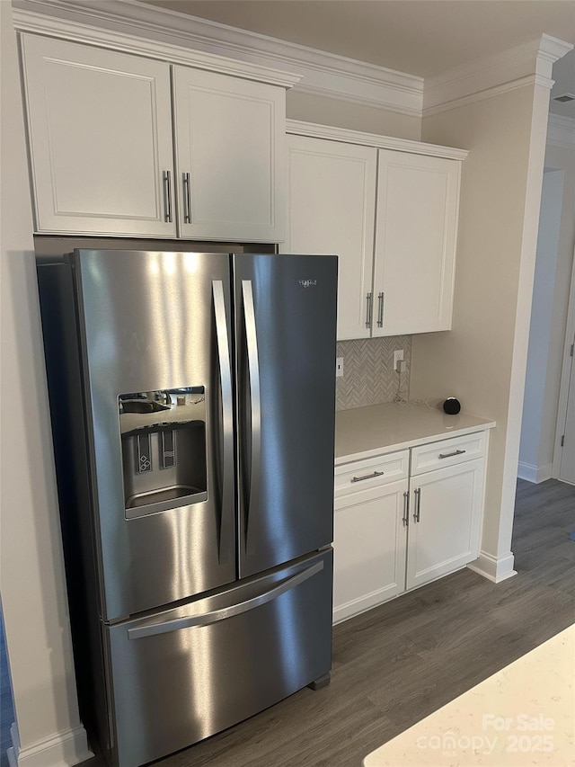 kitchen featuring crown molding, stainless steel fridge with ice dispenser, backsplash, and white cabinets