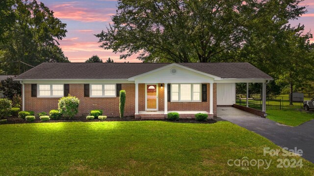 ranch-style home featuring a yard and a carport