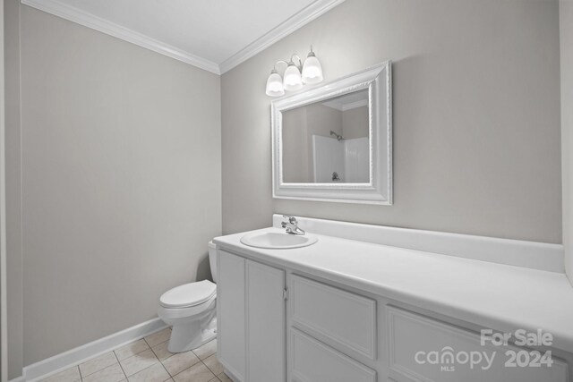 bathroom featuring tile patterned flooring, vanity, toilet, and crown molding