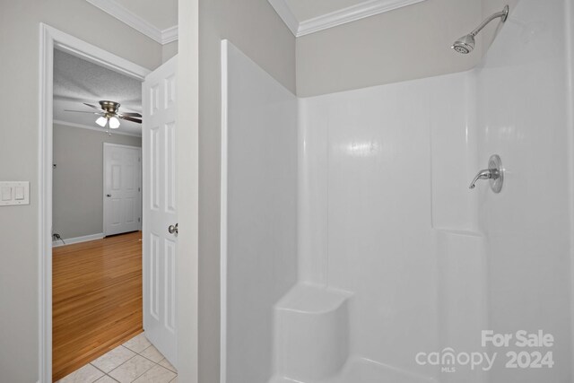 bathroom featuring crown molding, ceiling fan, a shower, and tile patterned floors