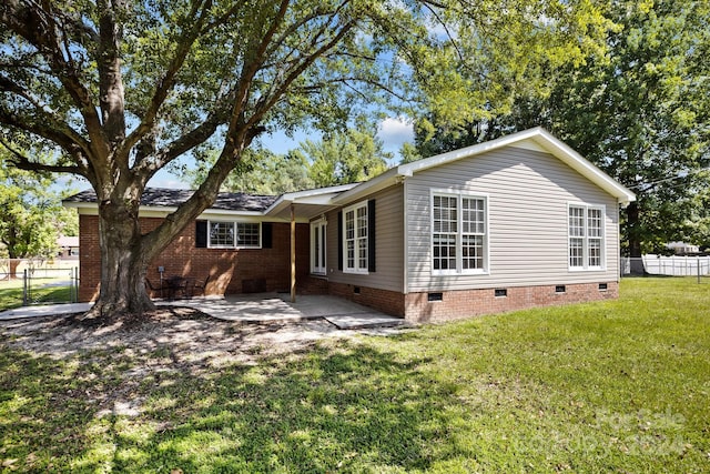 rear view of property featuring a yard and a patio