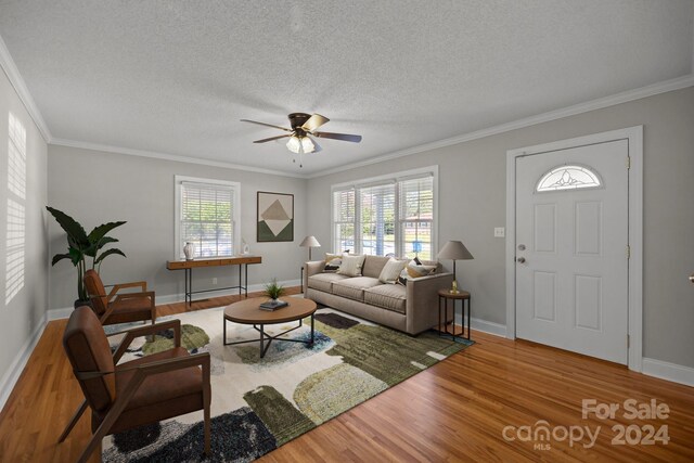 living room featuring hardwood / wood-style flooring, crown molding, and a healthy amount of sunlight