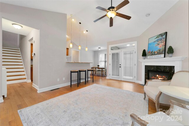 living room featuring wood finished floors, stairway, baseboards, and a premium fireplace