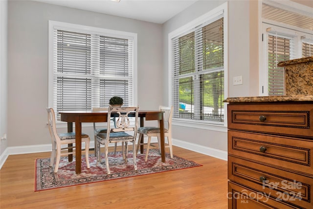 dining space featuring light wood finished floors and baseboards