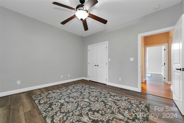 unfurnished bedroom with visible vents, ceiling fan, baseboards, and wood finished floors