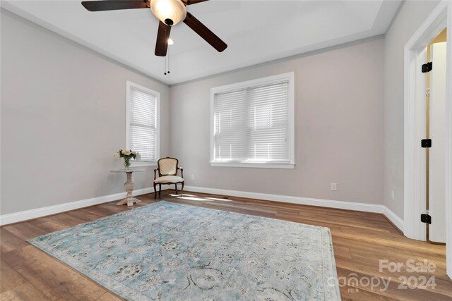 unfurnished room featuring a ceiling fan, baseboards, and wood finished floors