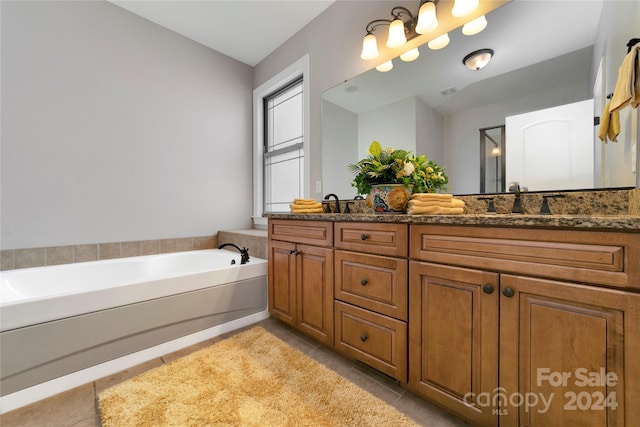 bathroom featuring a garden tub, double vanity, a sink, and tile patterned flooring