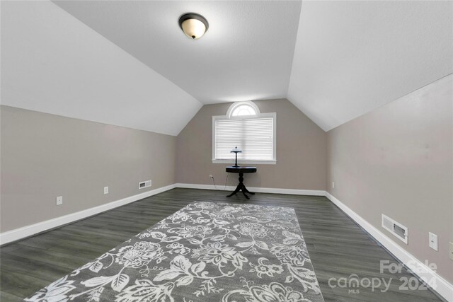 bonus room featuring lofted ceiling, baseboards, visible vents, and wood finished floors