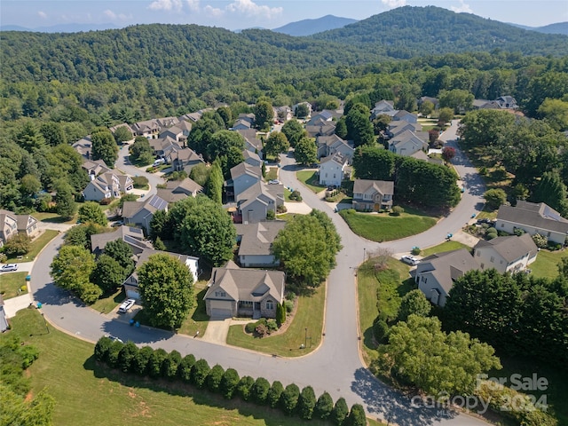 drone / aerial view with a mountain view, a wooded view, and a residential view