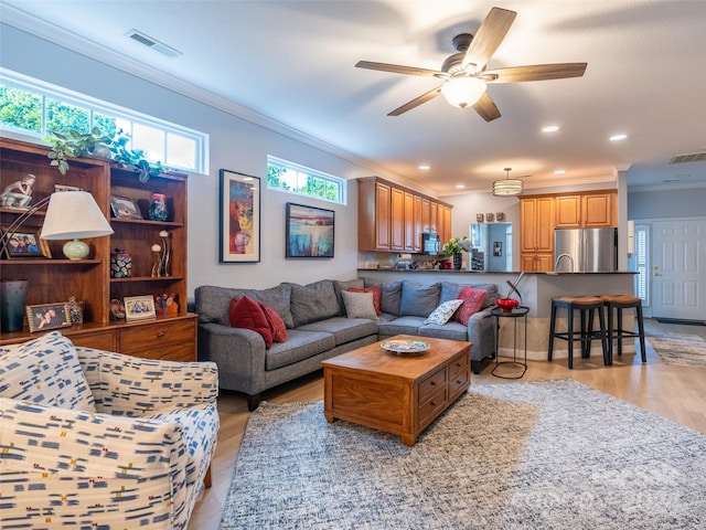 living room featuring ceiling fan, light hardwood / wood-style flooring, and ornamental molding