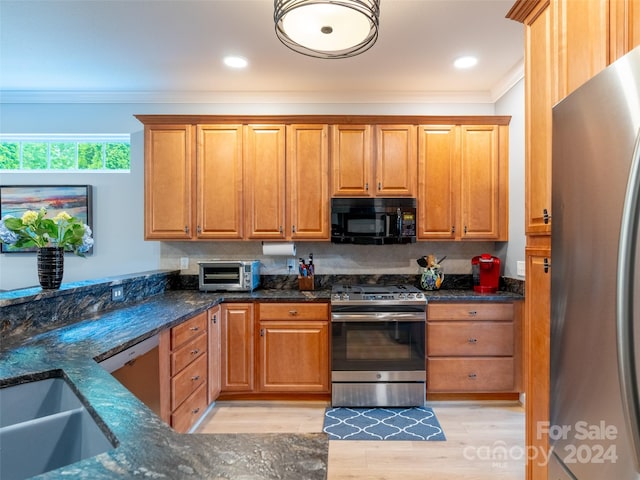 kitchen with dark stone counters, light hardwood / wood-style floors, decorative backsplash, and stainless steel appliances