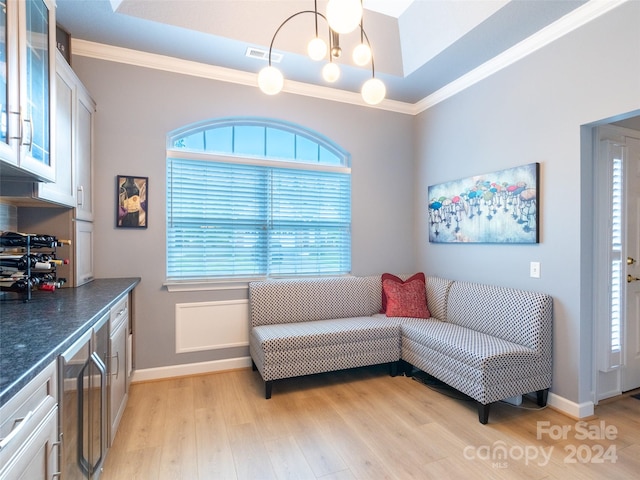 living room featuring a notable chandelier, plenty of natural light, light hardwood / wood-style floors, and crown molding