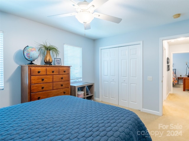 carpeted bedroom with ceiling fan and a closet