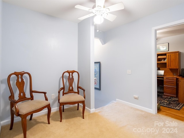 sitting room with light hardwood / wood-style floors and ceiling fan