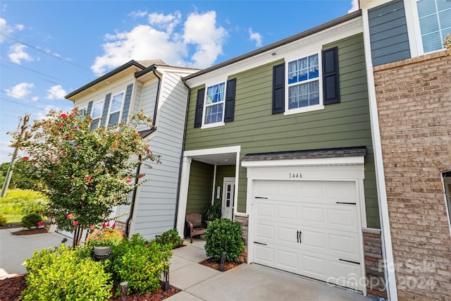 townhome / multi-family property with an attached garage and driveway