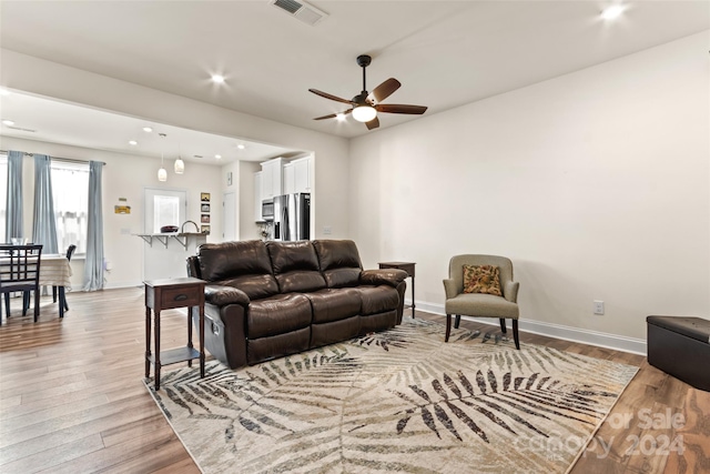 living room featuring light wood-type flooring and ceiling fan