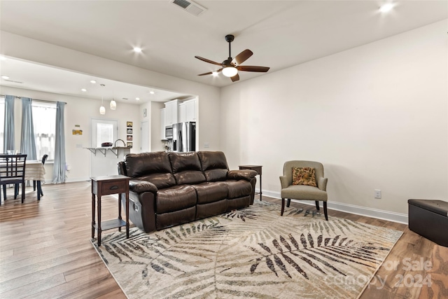 living area with ceiling fan, light wood finished floors, recessed lighting, baseboards, and visible vents
