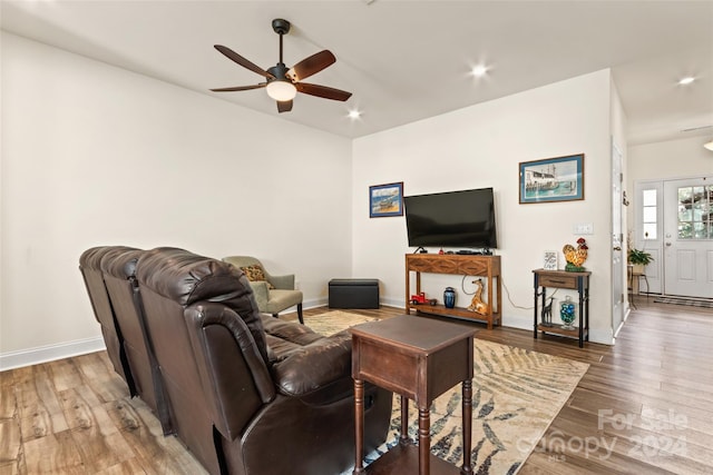 living room with baseboards, ceiling fan, and wood finished floors