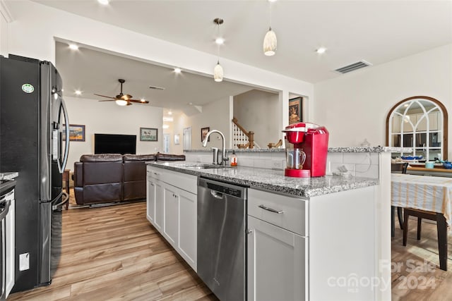 kitchen with light hardwood / wood-style flooring, hanging light fixtures, stainless steel appliances, and sink