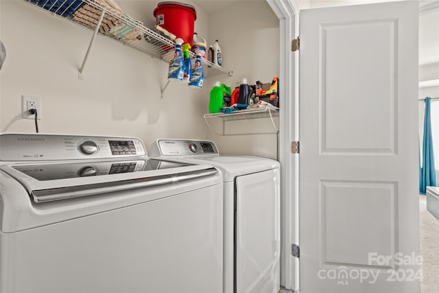 clothes washing area with washer and clothes dryer