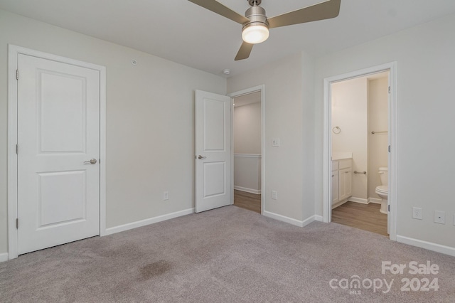 unfurnished bedroom featuring ceiling fan, light colored carpet, and ensuite bathroom