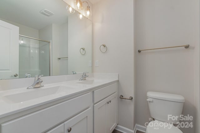 bathroom with toilet, an enclosed shower, and vanity