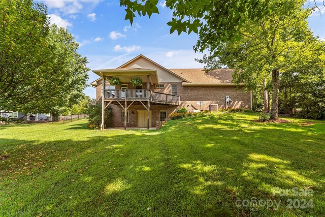 back of property with a lawn and a wooden deck