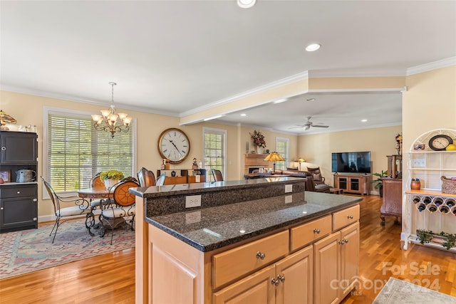 kitchen featuring light hardwood / wood-style floors, ceiling fan with notable chandelier, and ornamental molding