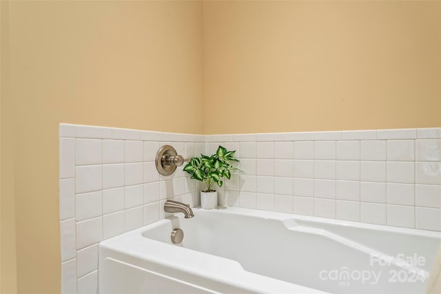 bathroom with tile walls and a tub