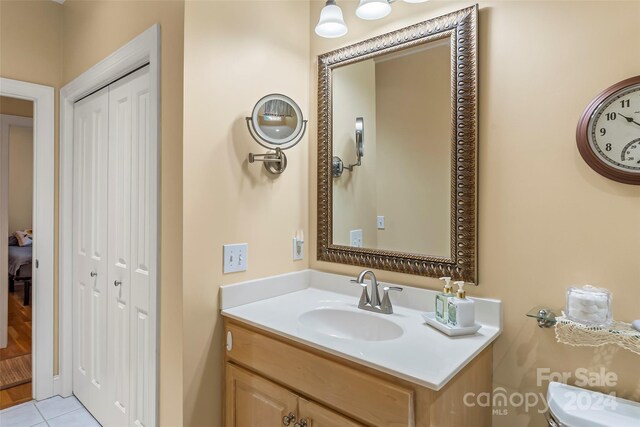 bathroom featuring tile patterned flooring, toilet, and vanity