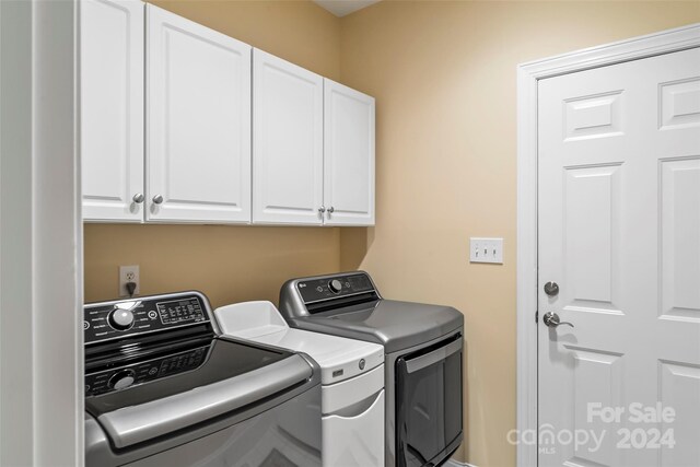 laundry room with cabinets and washing machine and clothes dryer