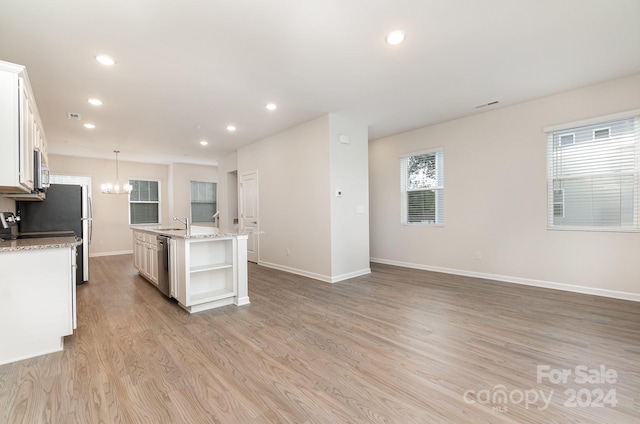 kitchen featuring white cabinets, a center island with sink, light hardwood / wood-style flooring, pendant lighting, and stainless steel appliances