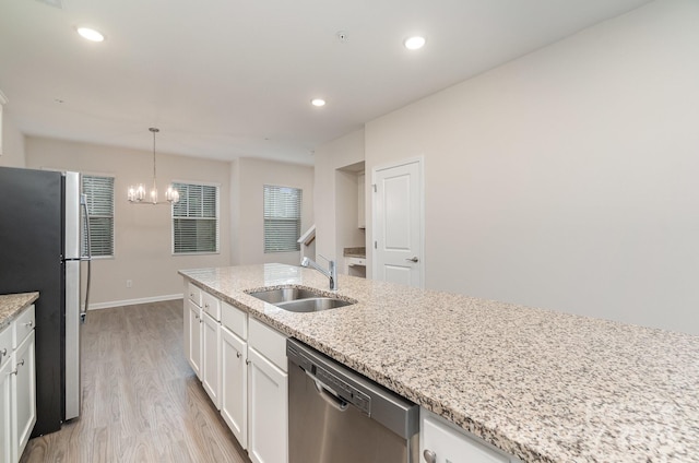 kitchen featuring white cabinetry, light wood-type flooring, sink, pendant lighting, and stainless steel appliances