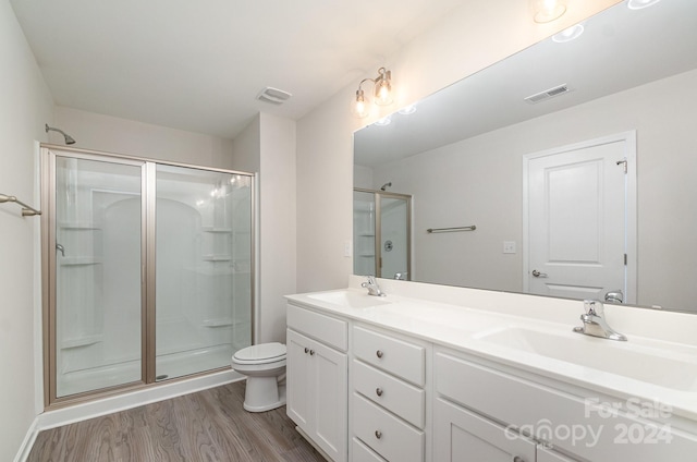 bathroom with vanity, walk in shower, toilet, and hardwood / wood-style flooring