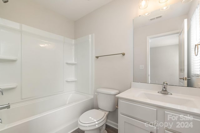 full bathroom featuring vanity, hardwood / wood-style flooring, toilet, and washtub / shower combination