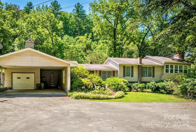 ranch-style house featuring a front yard, a garage, and a carport