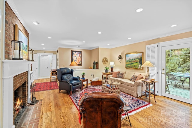 living room featuring crown molding, a brick fireplace, brick wall, and light hardwood / wood-style floors