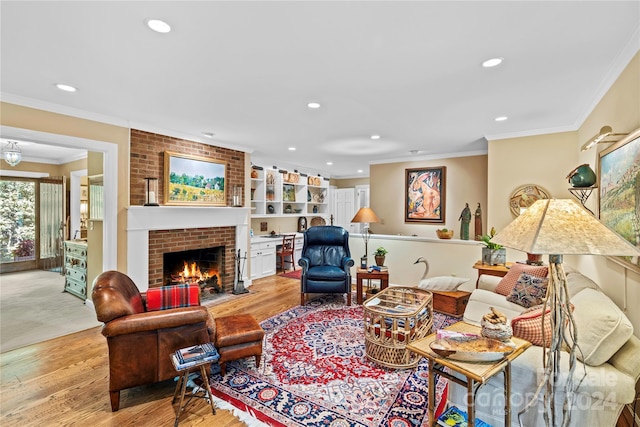 living room with brick wall, ornamental molding, light wood-type flooring, and a fireplace