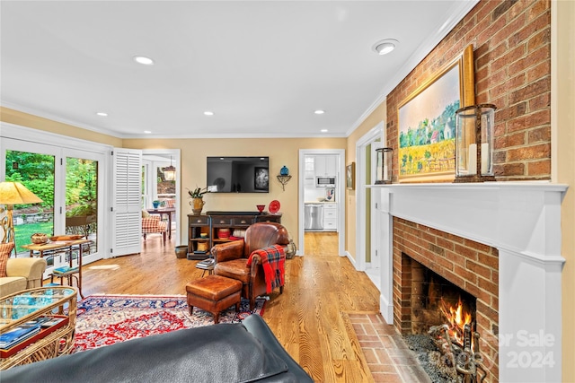 living room featuring ornamental molding, light wood-type flooring, and a fireplace