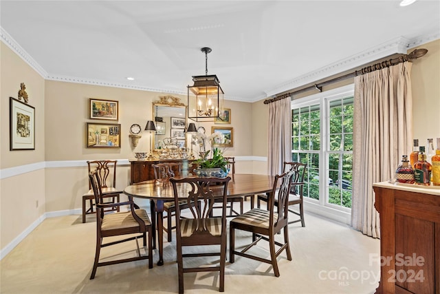 carpeted dining area with crown molding, a healthy amount of sunlight, and an inviting chandelier