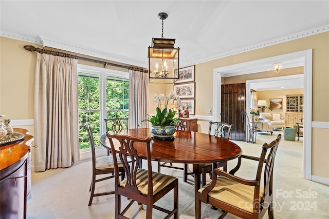 carpeted dining area with crown molding, plenty of natural light, and an inviting chandelier