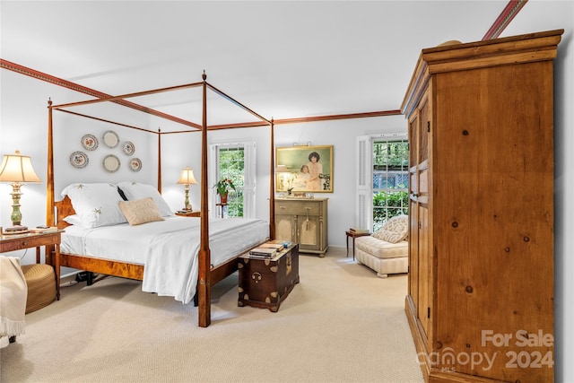 bedroom featuring multiple windows, ensuite bathroom, crown molding, and carpet floors