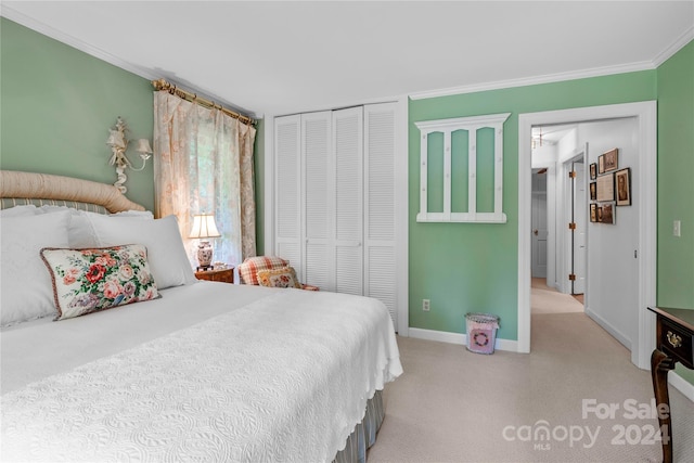 bedroom featuring crown molding, light colored carpet, and a closet