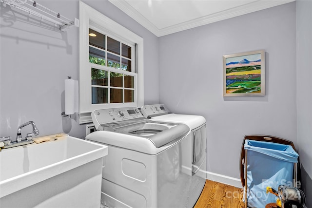 washroom with ornamental molding, light hardwood / wood-style flooring, sink, and independent washer and dryer