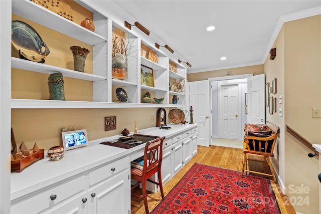 home office with light wood-type flooring and crown molding