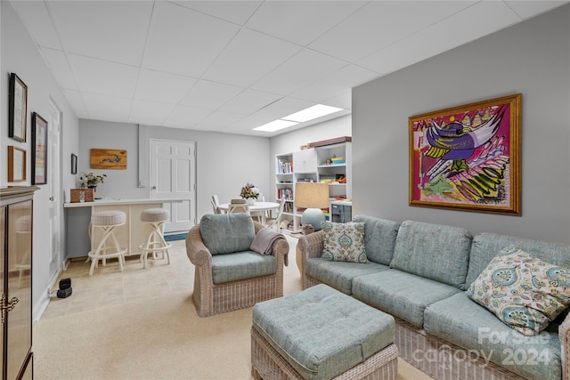 living room featuring light colored carpet and a drop ceiling