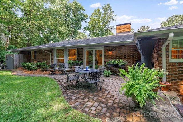 rear view of house with french doors, a yard, and a patio