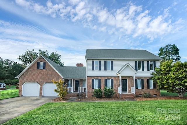 colonial inspired home with a garage and a front yard