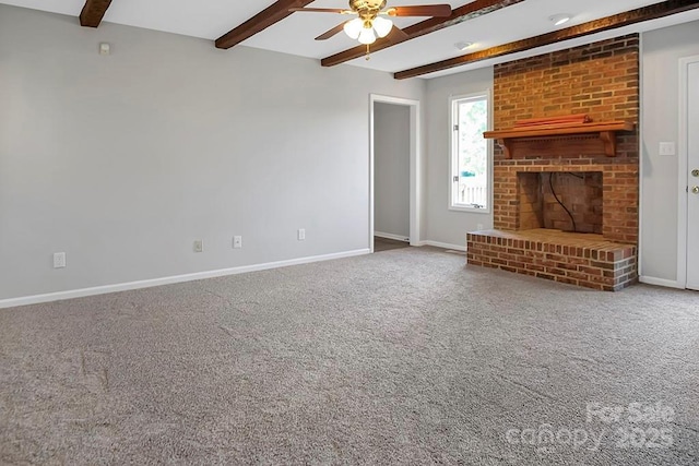 unfurnished living room with a brick fireplace, carpet, beam ceiling, and baseboards